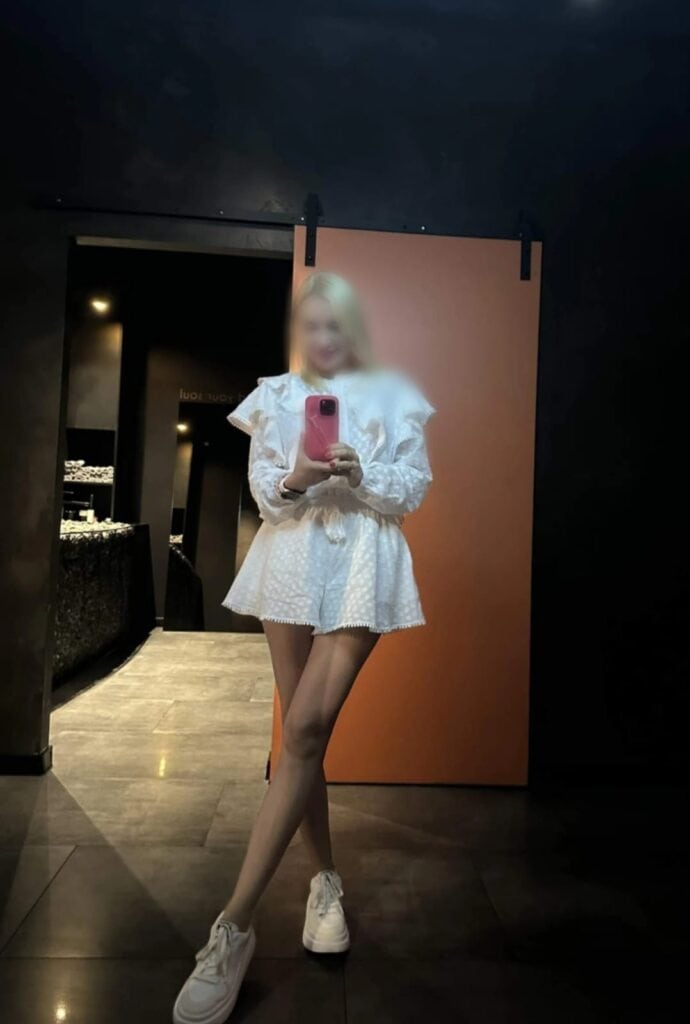 Persona con vestido blanco sacando foto en espejo